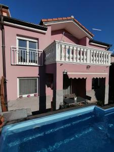 a pink house with a swimming pool in front of it at House Srima-Vodice Dalmatia in Srima