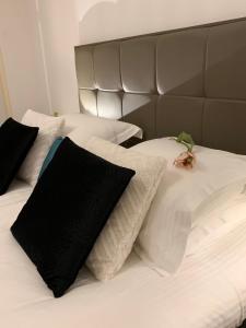 een bed met zwarte en witte kussens erop bij Harlingen Garden Apartment in Midlum