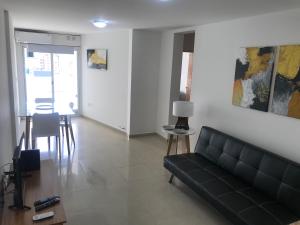 sala de estar con sofá negro y mesa en Jardines del Boulevard 3, Nueva cordoba en Córdoba
