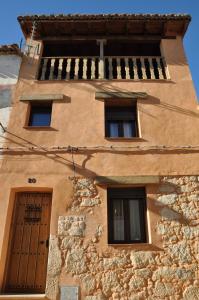 a building with four windows and a door at Casa rural La Piedrapipa in Madrigal de la Vera