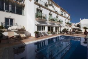 a hotel with a swimming pool in front of a building at Vila Sao Vicente Boutique (Adults Only) in Albufeira