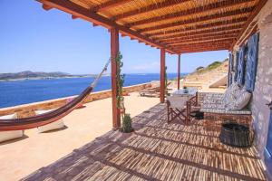 a porch with a hammock and a view of the ocean at Antiparos Vibes in Agios Georgios