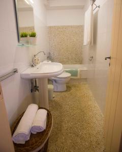 a bathroom with a sink and a toilet and a tub at Antiparos Vibes in Agios Georgios +37 photos