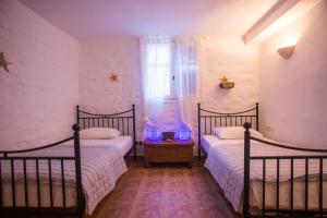 a bedroom with two beds and a window at Antiparos Vibes in Agios Georgios