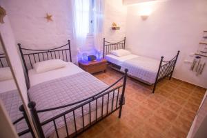 two twin beds in a room with at Antiparos Vibes in Agios Georgios