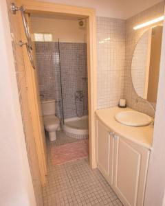 a bathroom with a toilet and a tub and a sink at Antiparos Vibes in Agios Georgios