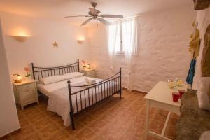a bedroom with a bed and a ceiling fan at Antiparos Vibes in Agios Georgios