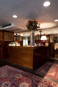 a lobby with a counter with a vase of flowers at Hotel Locanda Al Sole in Castello di Godego