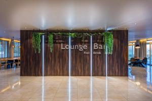 a lobby with a lounge bar sign on a wooden wall at Alexandra Beach Resort & Spa in Tsilivi