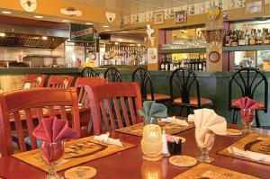 a restaurant with tables and chairs and a bar at Windsor Hotel in East Windsor