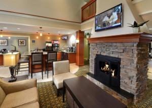 sala de estar con chimenea y TV encima. en Staybridge Suites Raleigh-Durham Airport-Morrisville, an IHG Hotel, en Morrisville