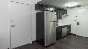 a kitchen with a stainless steel refrigerator and cabinets at Candlewood Suites - Queretaro Juriquilla, an IHG Hotel in Quer&eacute;taro