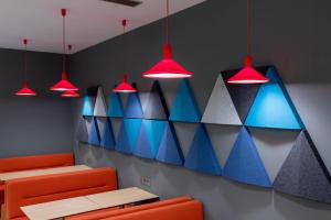 une salle à manger avec des chaises et des lumières colorées dans l'établissement Holiday Inn Express Porto Exponor by IHG, à Leça da Palmeira