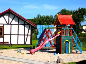 a playground with a slide and a play structure at 4 Domki in Sarbinowo