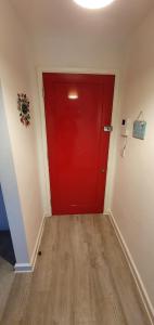 a red door in a room with a wooden floor at Palm Court in Bournemouth