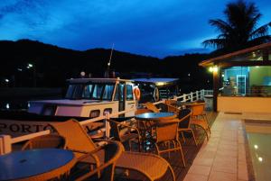 un restaurante con mesas y sillas y un barco en Pousada Porto Canal, en Cabo Frío