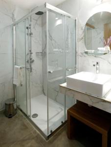 a bathroom with a glass shower and a sink at Cosmopolis Multi-Venue in Larnaca +18 photos