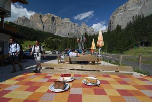 a table with food on it with a mountain in the background at Wellness Hotel Lupo Bianco in Canazei