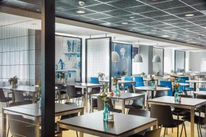 uma sala de jantar com mesas e cadeiras azuis em Holiday Inn Express Rotterdam - Central Station, an IHG Hotel em Roterdão