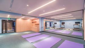 - une salle de yoga avec des tapis violets au sol dans l'établissement Holiday Inn Express Kunming West, an IHG Hotel, à Kunming