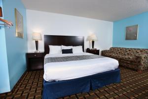 a hotel room with a large bed and a couch at Coratel Inn & Suites by Jasper Newton in Newton