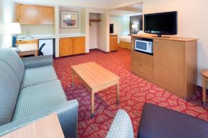 a hotel room with a couch and a television at Holiday Inn Express Roseburg, an IHG Hotel in Roseburg