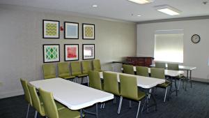 普萊恩維尤的住宿－普萊恩維爾智選假日酒店，一间教室,配有白色的桌椅和白色的板子