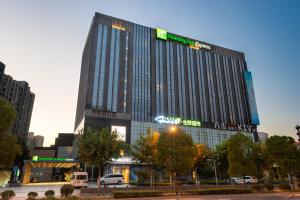 ein hohes Gebäude mit einem Schild darauf in der Unterkunft Holiday Inn Express Shanghai Jinsha by IHG in Shanghai
