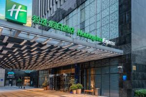 ein Gebäude mit einem Schild an der Seite in der Unterkunft Holiday Inn Express Shanghai Jinsha by IHG in Shanghai