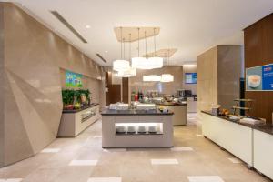 a large kitchen with a counter in a restaurant at Holiday Inn Express Shanghai Jinsha, an IHG Hotel in Shanghai