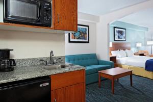 a hotel room with a kitchen and a bed at Holiday Inn Express Richmond-Brandermill-Hull Street by IHG in Brandermill
