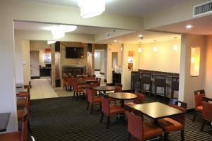 a restaurant with tables and chairs and a fireplace at Holiday Inn Express Pittsburgh - Munhall, an IHG Hotel in Munhall