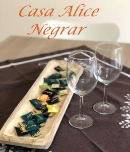 due bicchieri di vino seduti accanto a un piatto di cibo di Casa Alice Negrar a Negrar