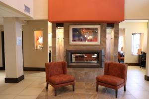 een lobby met 2 stoelen en een open haard bij Holiday Inn Express Pittsburgh - Munhall, an IHG Hotel in Munhall