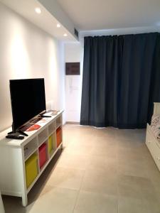 ein Wohnzimmer mit einem TV auf einer Kommode in der Unterkunft GARDEN 128 in Corralejo