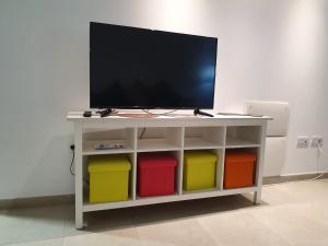a tv on a white table with colorful bins at GARDEN 128 in Corralejo