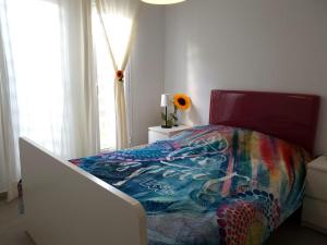 ein Schlafzimmer mit einem Bett mit einer bunten Bettdecke in der Unterkunft GARDEN 128 in Corralejo + 47 Fotos