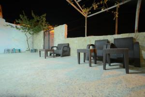 a group of chairs and tables in the sand at Petra Lion Hotel in Wadi Musa