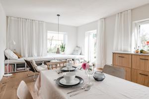 a white living room with a table and chairs at Haizing 26 in Haizing