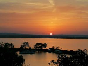 una puesta de sol sobre un lago con barcos en el agua en Penzion Nad jezerem en Pavlov