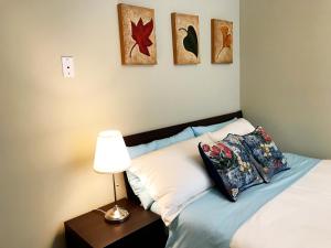 een slaapkamer met een bed met 2 kussens en een lamp bij Hannah's Heavenly Home in Surrey +19 foto's