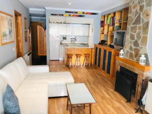 een woonkamer met een witte bank en een open haard bij LUXURY GINEBRA in Sierra Nevada +3 foto's