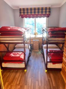 een kamer met 3 stapelbedden en een raam bij LUXURY GINEBRA in Sierra Nevada