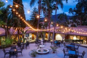 un patio con mesas, sillas y luces en Catalina Canyon Inn, en Avalon