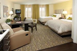 a hotel room with two beds and a desk at Candlewood Suites Sayre, an IHG Hotel in Sayre