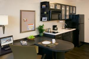 a kitchen with a table with a laptop on it at Candlewood Suites Sayre, an IHG Hotel in Sayre