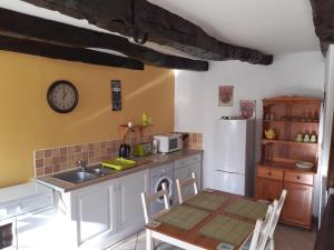 a kitchen with a table and a sink and a refrigerator at Ty Kena in Saint-Gilles-du-Vieux-Marché