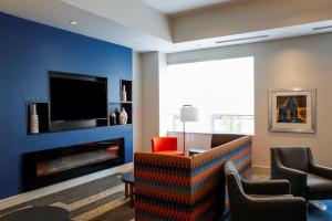 a living room with a fireplace and a tv at Holiday Inn Express & Suites Downtown Louisville, an IHG Hotel in Louisville