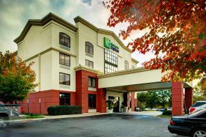 ein Hotelgebäude mit einem davor geparkt in der Unterkunft Holiday Inn Express Richmond Airport, an IHG Hotel in Sandston