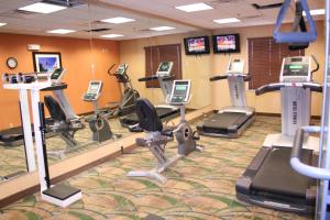 un gimnasio con varias cintas de correr y bicicletas estáticas en Holiday Inn Express Pratt, an IHG Hotel, en Pratt